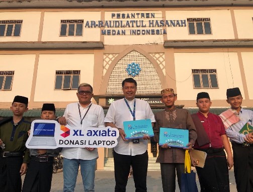 Head of Sales XL Axiata Greater Medan, Horas Lubis (tengah) bersama dengan KMI Pondok Pesantren Ar-Raudlatul Hasanah, Muhammad Ilyas (ketiga dari kanan) pada saat acara penyerahan donasi laptop di Medan, Sumatera Utara, belum lama ini.